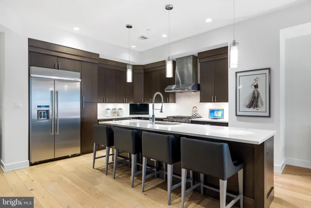 a kitchen with stainless steel appliances granite countertop a sink and a refrigerator
