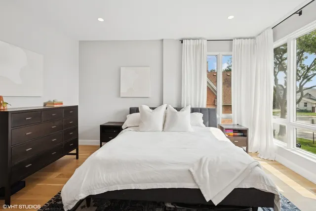 a bedroom with a bed and a large window