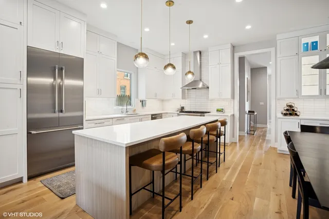 a kitchen with kitchen island granite countertop a sink a center island and stainless steel appliances