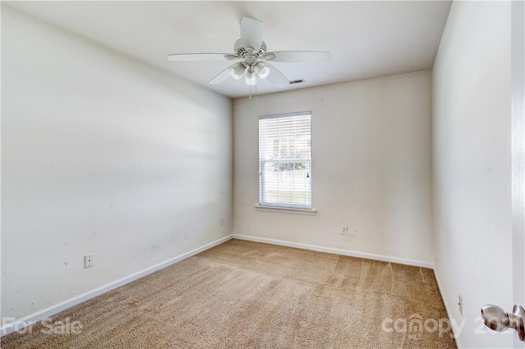 1310 Smokey Quartz Lane Fort Mill, SC 29708 - Photo 11 of 18 an empty room with a chandelier fan and windows