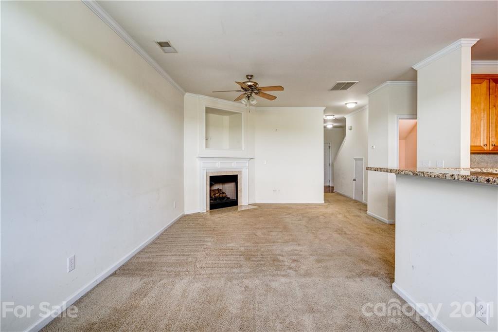 1310 Smokey Quartz Lane Fort Mill, SC 29708 - Photo 5 of 18 an empty room with a fireplace and a chandelier fan