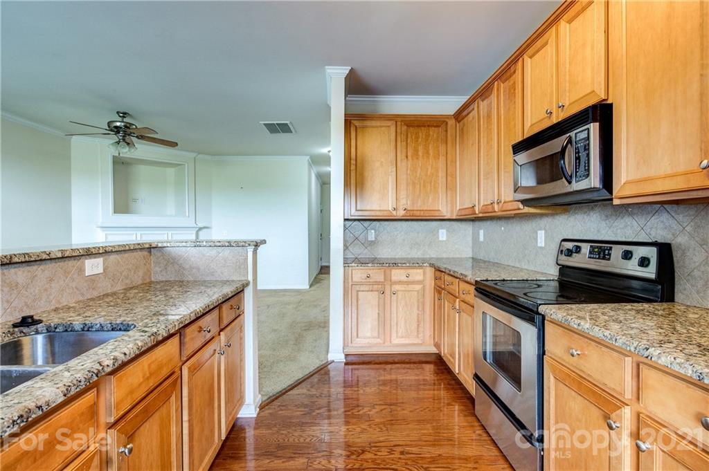 1310 Smokey Quartz Lane Fort Mill, SC 29708 - Photo 8 of 18 a kitchen with stainless steel appliances granite countertop a sink a stove and a microwave