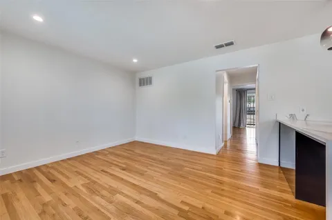 a view of empty room with wooden floor and fireplace