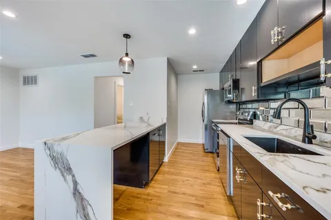 a kitchen with a sink stove top oven and refrigerator