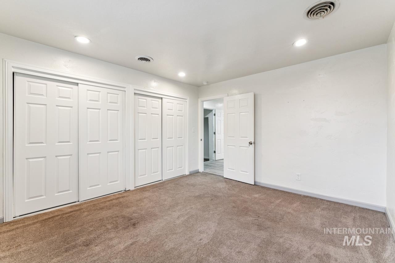317 East Ithaca Street Caldwell, ID 83605 - Photo 16 of 49 Unfurnished bedroom featuring two closets and carpet floors