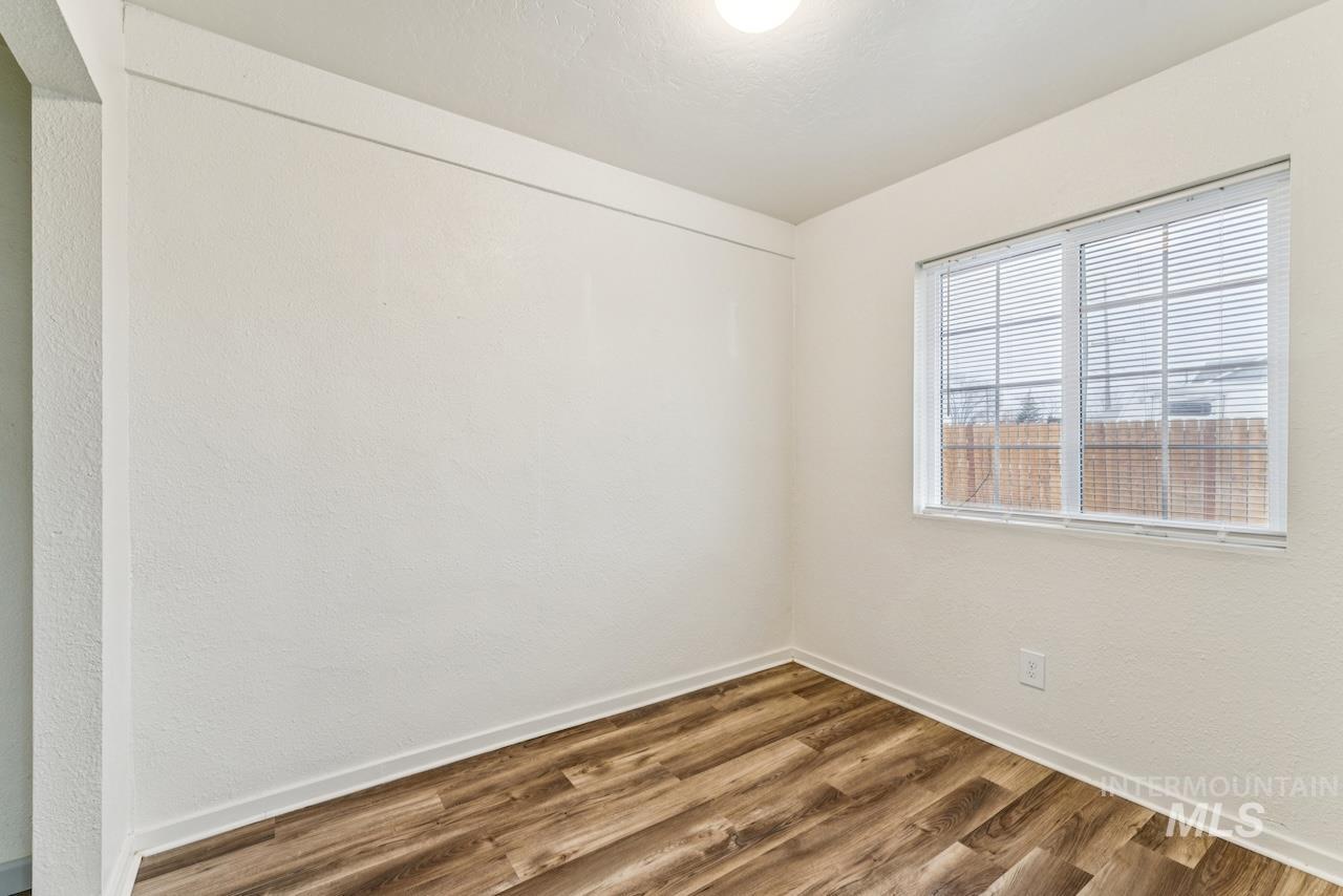 317 East Ithaca Street Caldwell, ID 83605 - Photo 19 of 49 Spare room featuring wood finished floors and a textured wall