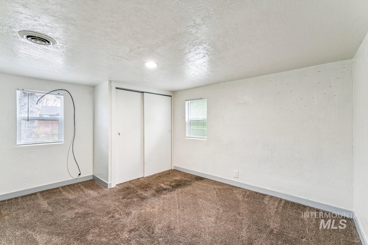 317 East Ithaca Street Caldwell, ID 83605 - Photo 24 of 49 Unfurnished bedroom with carpet flooring, a closet, a textured ceiling, and a textured wall