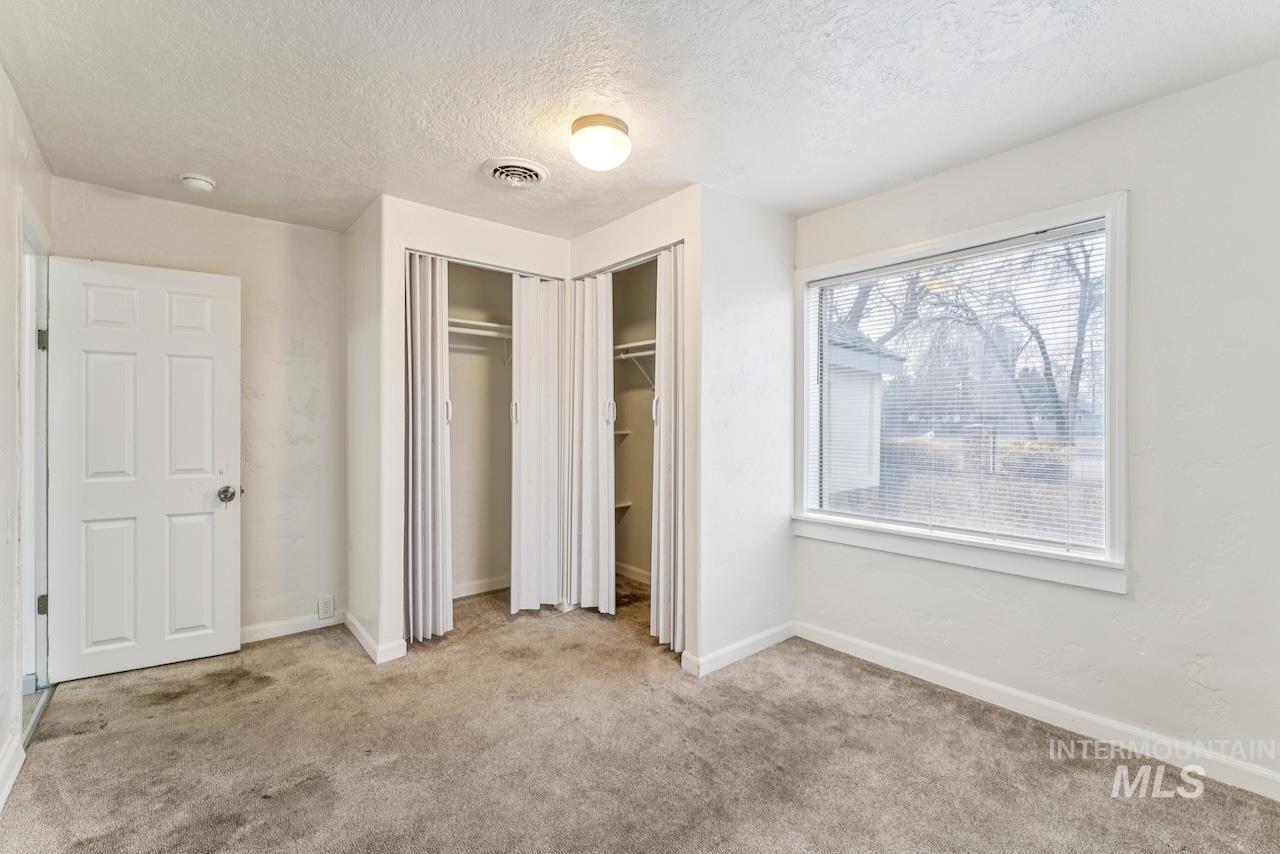317 East Ithaca Street Caldwell, ID 83605 - Photo 37 of 49 Unfurnished bedroom with light colored carpet, a textured ceiling, and a closet
