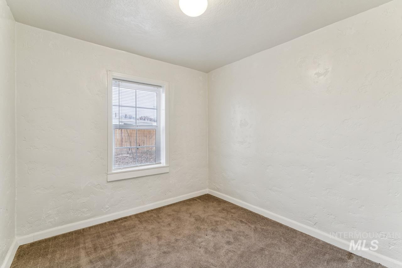 317 East Ithaca Street Caldwell, ID 83605 - Photo 39 of 49 Empty room with a textured wall and carpet floors