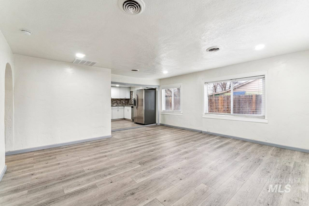 317 East Ithaca Street Caldwell, ID 83605 - Photo 7 of 49 Spare room with arched walkways, light wood-type flooring, recessed lighting, and a textured ceiling