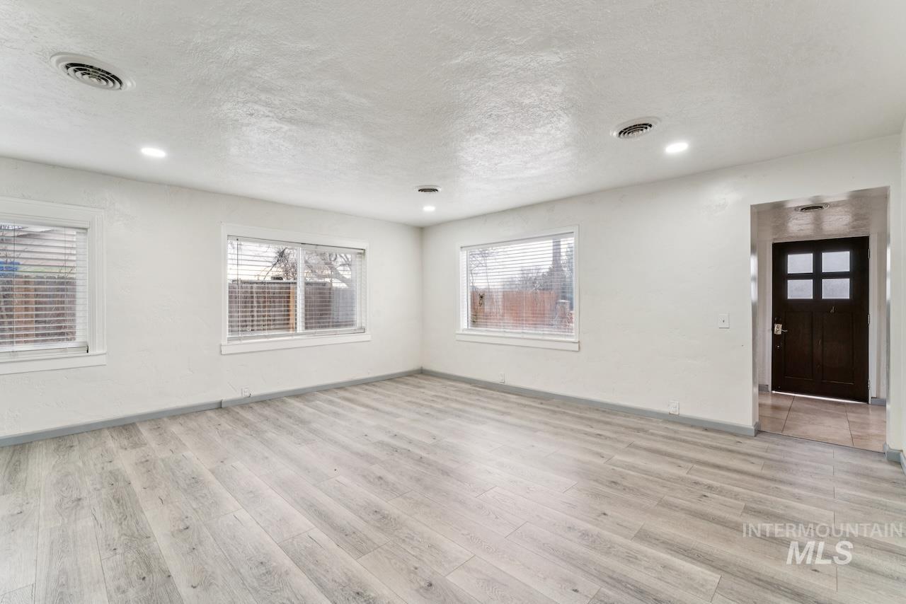 317 East Ithaca Street Caldwell, ID 83605 - Photo 8 of 49 Spare room featuring a textured ceiling, light wood-style floors, and plenty of natural light