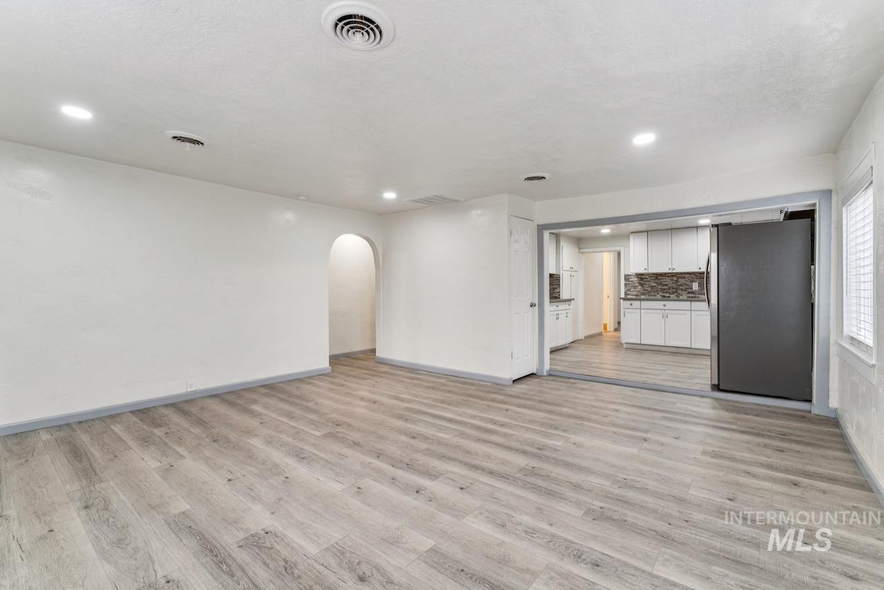 317 East Ithaca Street Caldwell, ID 83605 - Photo 9 of 49 Unfurnished living room featuring arched walkways, light wood-style floors, and recessed lighting