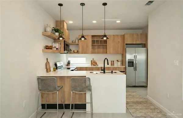 a kitchen with stainless steel appliances granite countertop a sink a stove and a refrigerator