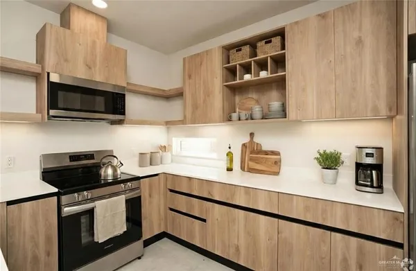 a kitchen with stainless steel appliances a stove a sink and a microwave