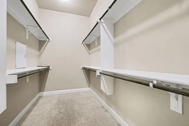 a view of walk in closet with empty racks