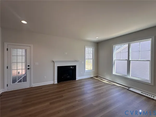 an empty room with windows and fireplace