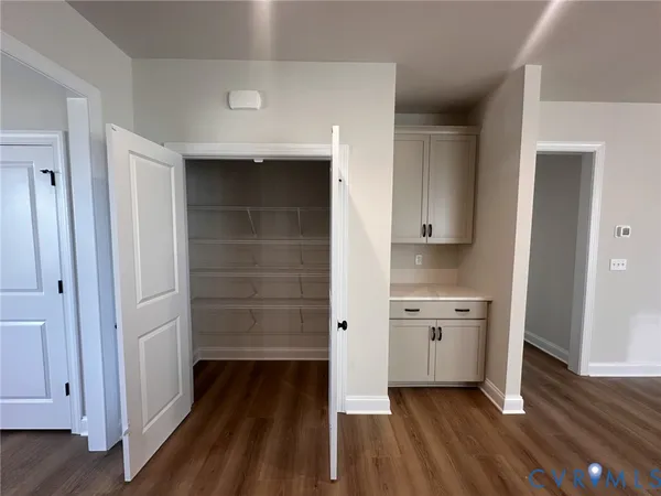 a view of a hallway with wooden floor and a sink