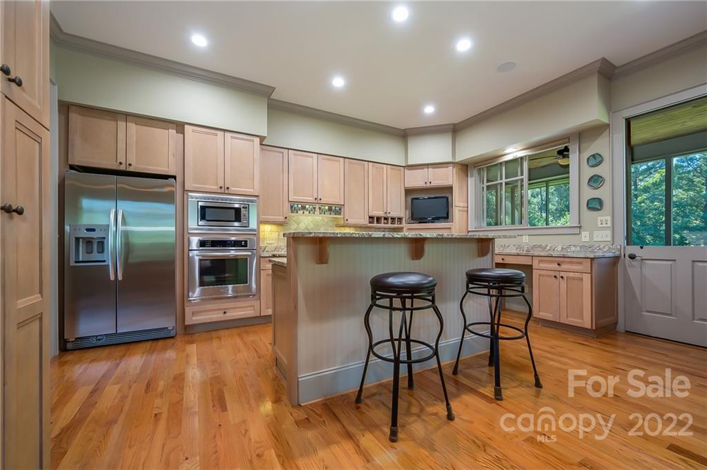 1360 South Phillips Road Columbus, NC 28722 - Photo 14 of 41 a kitchen with stainless steel appliances granite countertop a refrigerator a stove top oven and a dining table with wooden floor