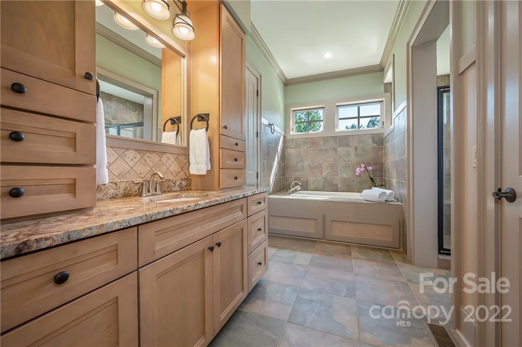 1360 South Phillips Road Columbus, NC 28722 - Photo 26 of 41 a bathroom with a granite countertop tub sink and mirror