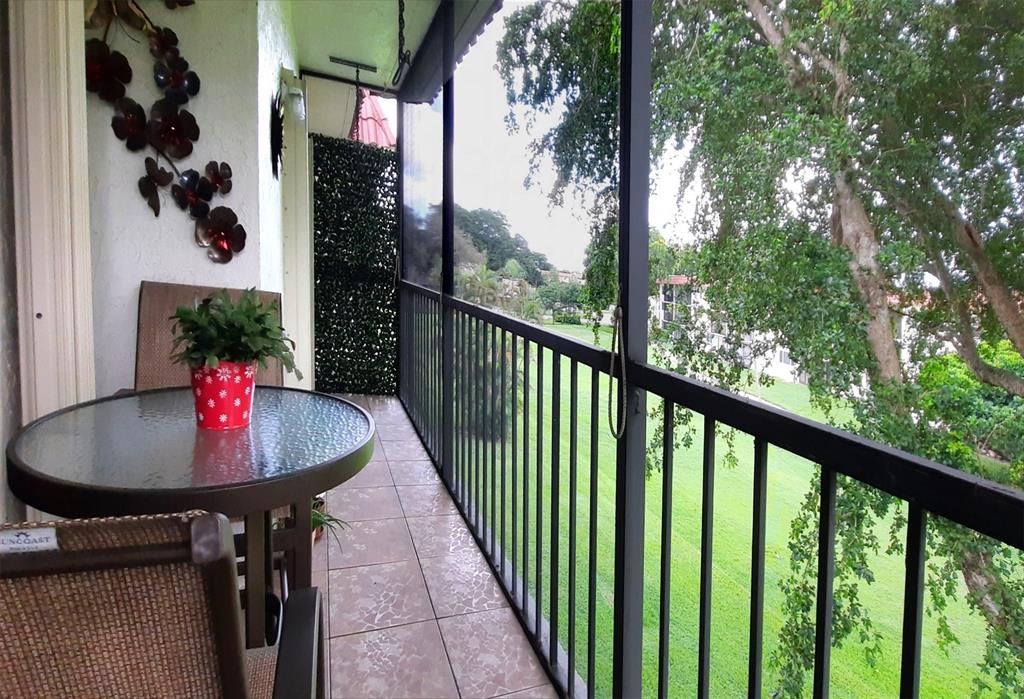 a balcony view with a table and chairs