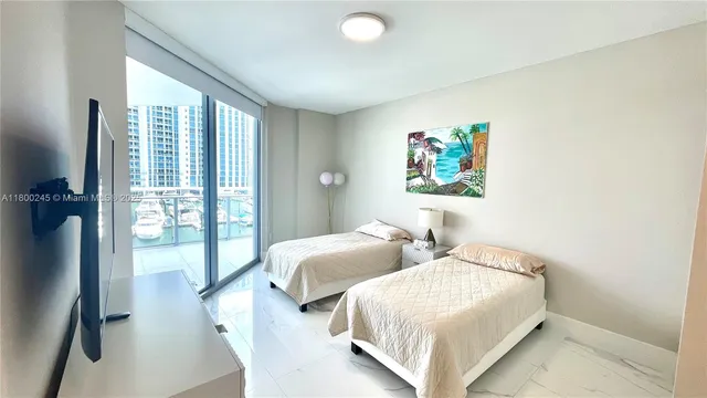 a bedroom with two beds and a large window