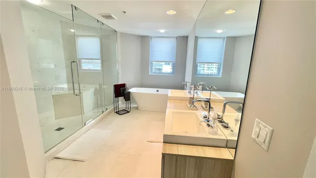 a bathroom with a sink mirror and shower