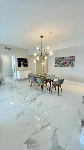a dining room with furniture and a chandelier