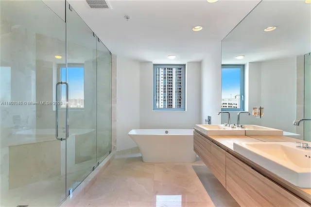 a spacious bathroom with a bathtub sink and mirror