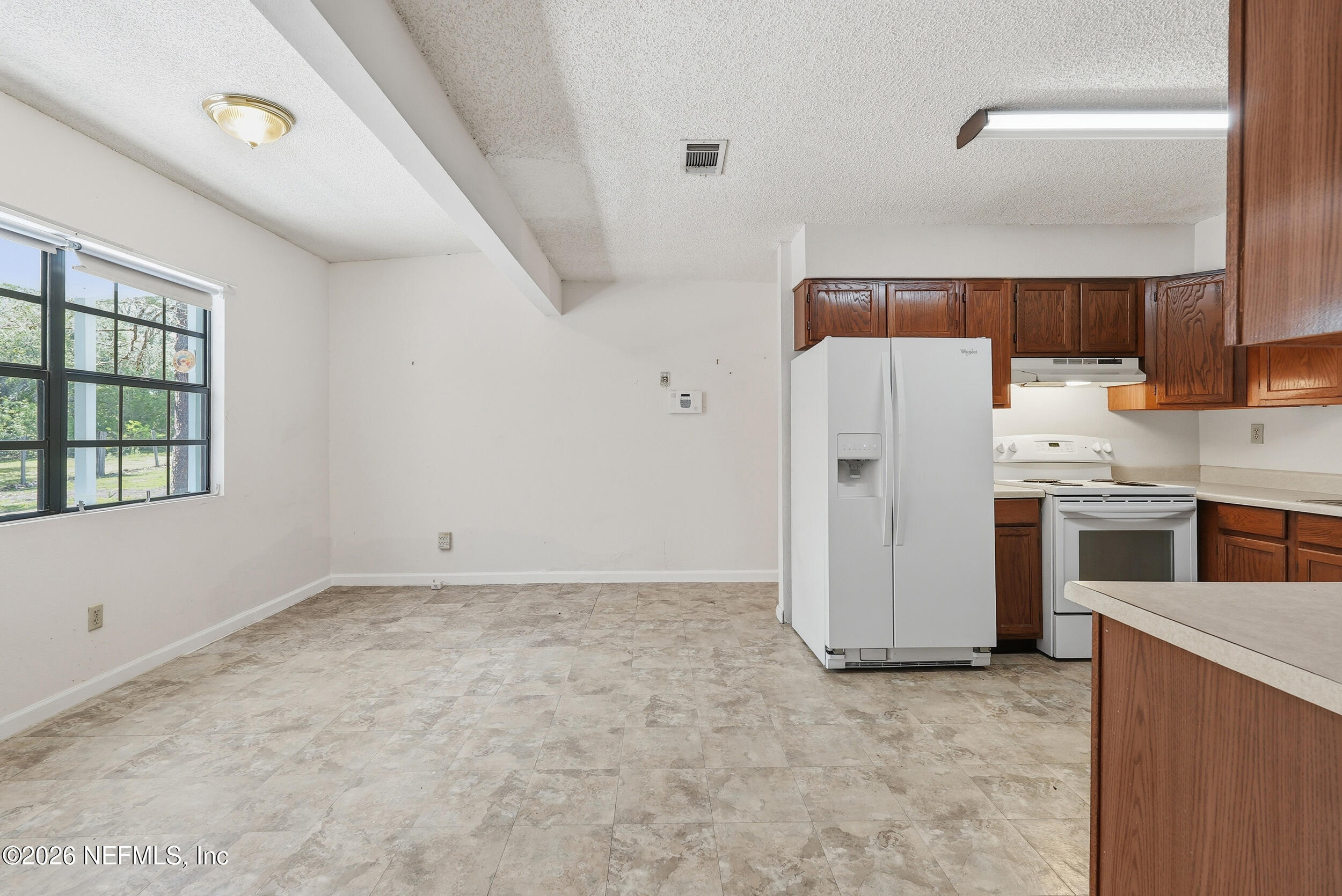 7593 Silver Sands Road Keystone Heights, FL 32656 - Photo 13 of 36 a view of a kitchen with refrigerator and microwave