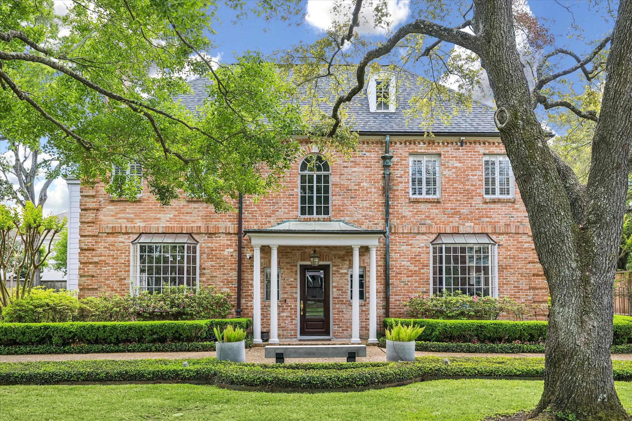 2133 Inwood Drive Houston, TX 77019 - Photo 1 of 22 Set beneath towering trees, the symmetrical façade and refined proportions of 2133 Inwood Drive create a timeless streetscape.