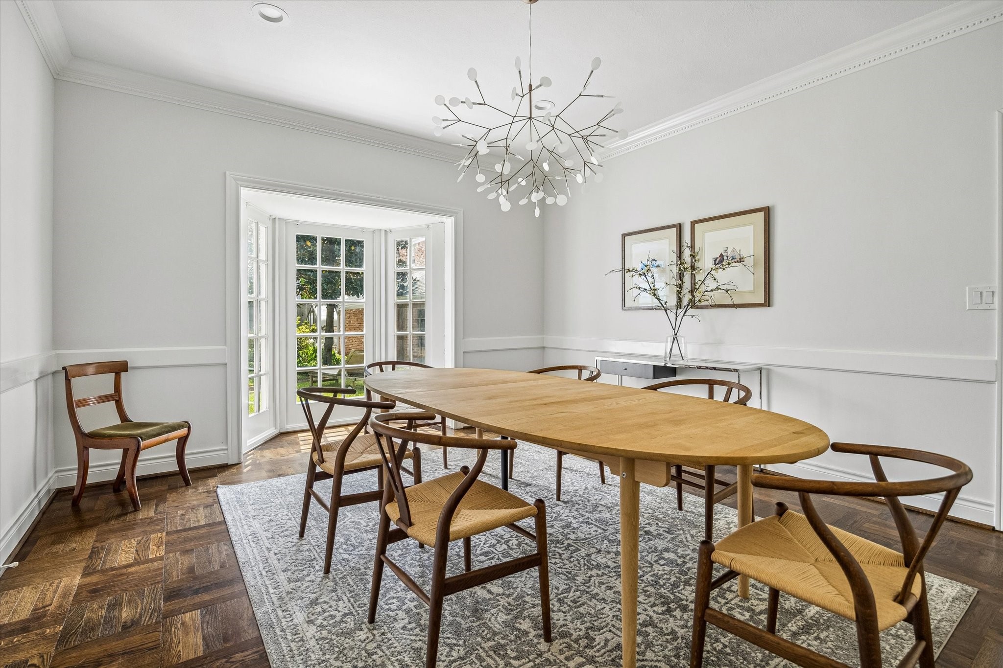 2133 Inwood Drive Houston, TX 77019 - Photo 11 of 22 Elegant parquet flooring and a sculptural chandelier define the dining room, while large bay windows bring in soft natural light.