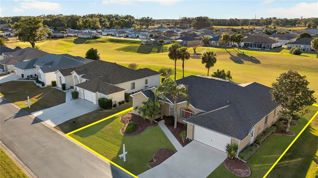 an aerial view of residential houses with outdoor space and ocean view