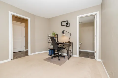 a view of a workspace with furniture and a window