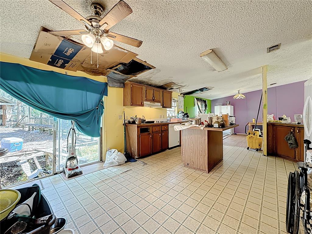 2414 Brock Road Plant City, FL 33565 - Photo 13 of 63 a kitchen with stainless steel appliances kitchen island granite countertop a table chairs in it and wooden floors