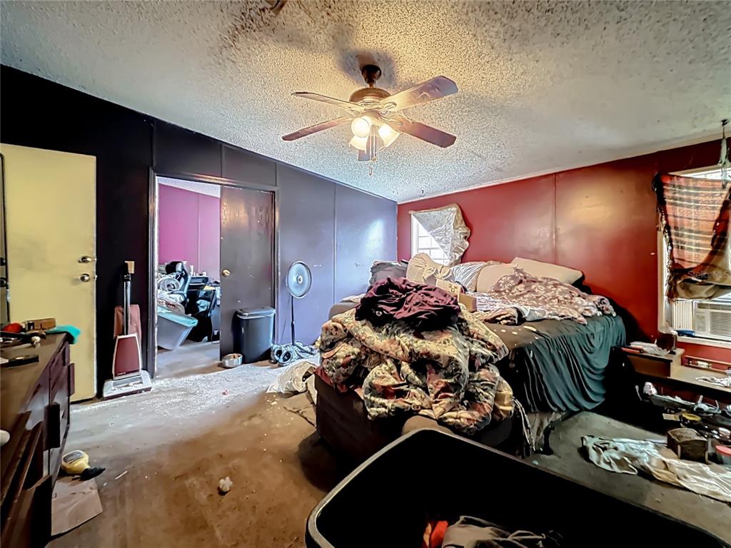2414 Brock Road Plant City, FL 33565 - Photo 34 of 63 a room with a bed mirror and a ceiling fan