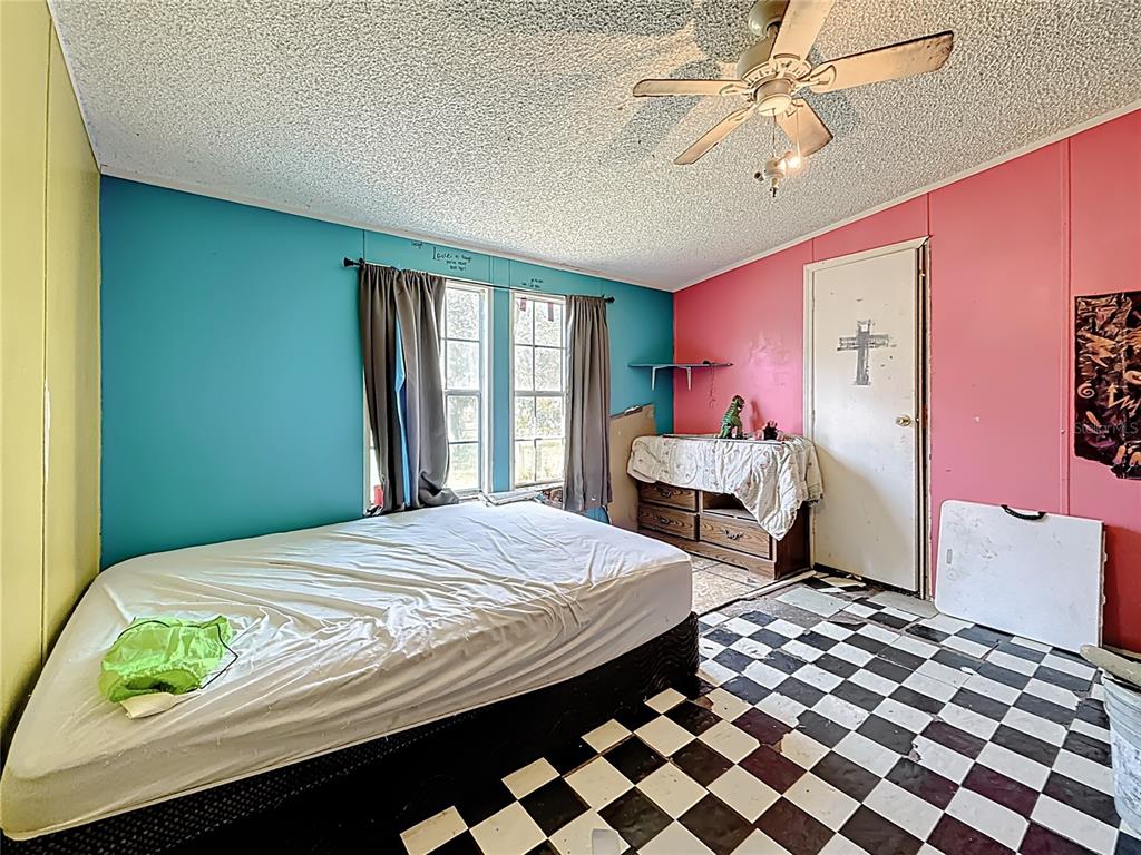 2414 Brock Road Plant City, FL 33565 - Photo 41 of 63 a bedroom with a bed and a chandelier