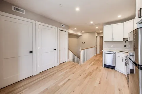 a large kitchen with a lot of counter space and wooden floor