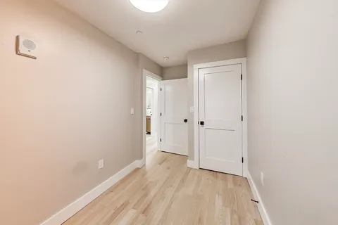 a view of a room with wooden floor and white doors