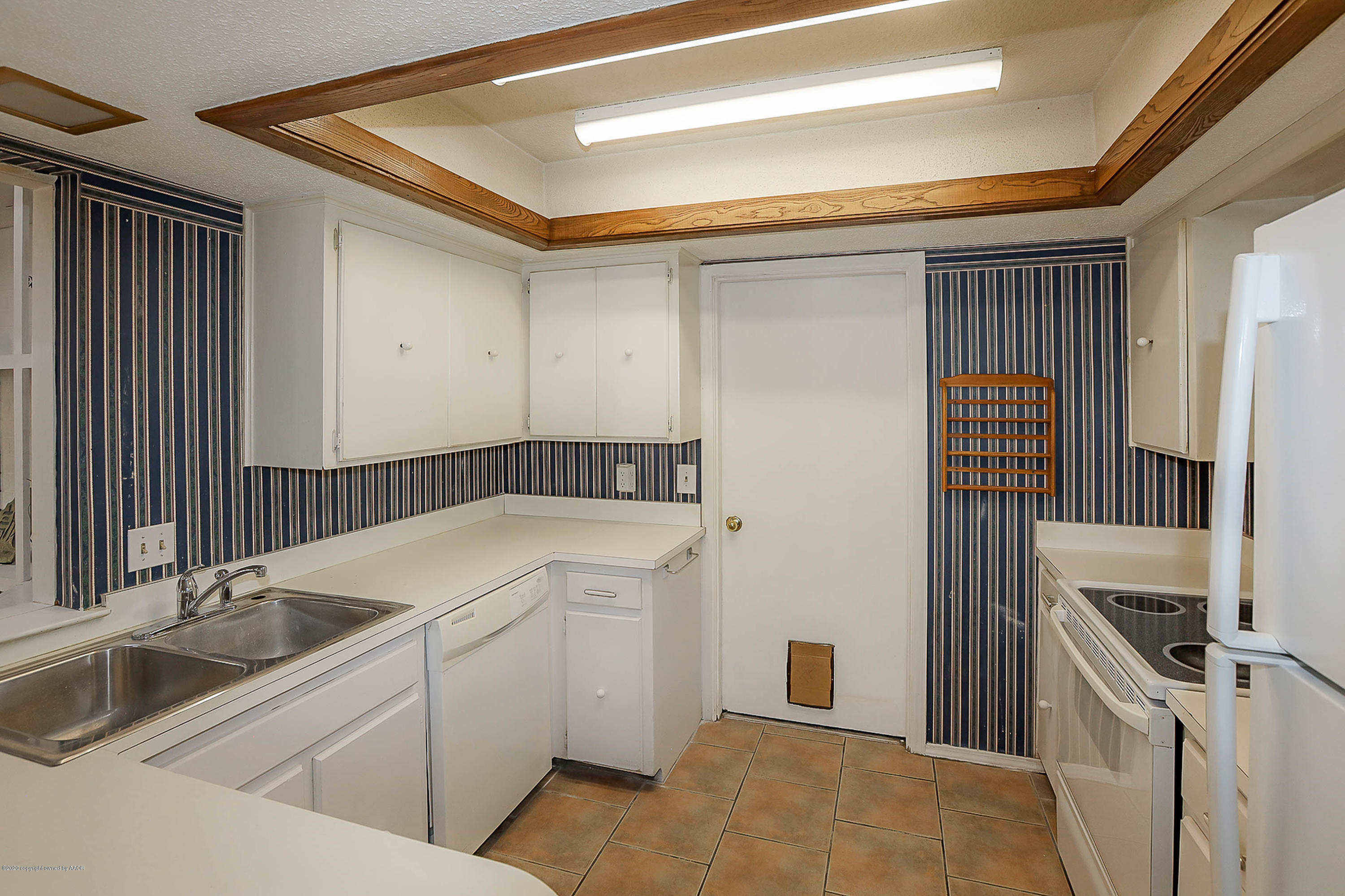2802 Shield Court Amarillo, TX 79110 - Photo 11 of 32 a kitchen with a sink and a refrigerator