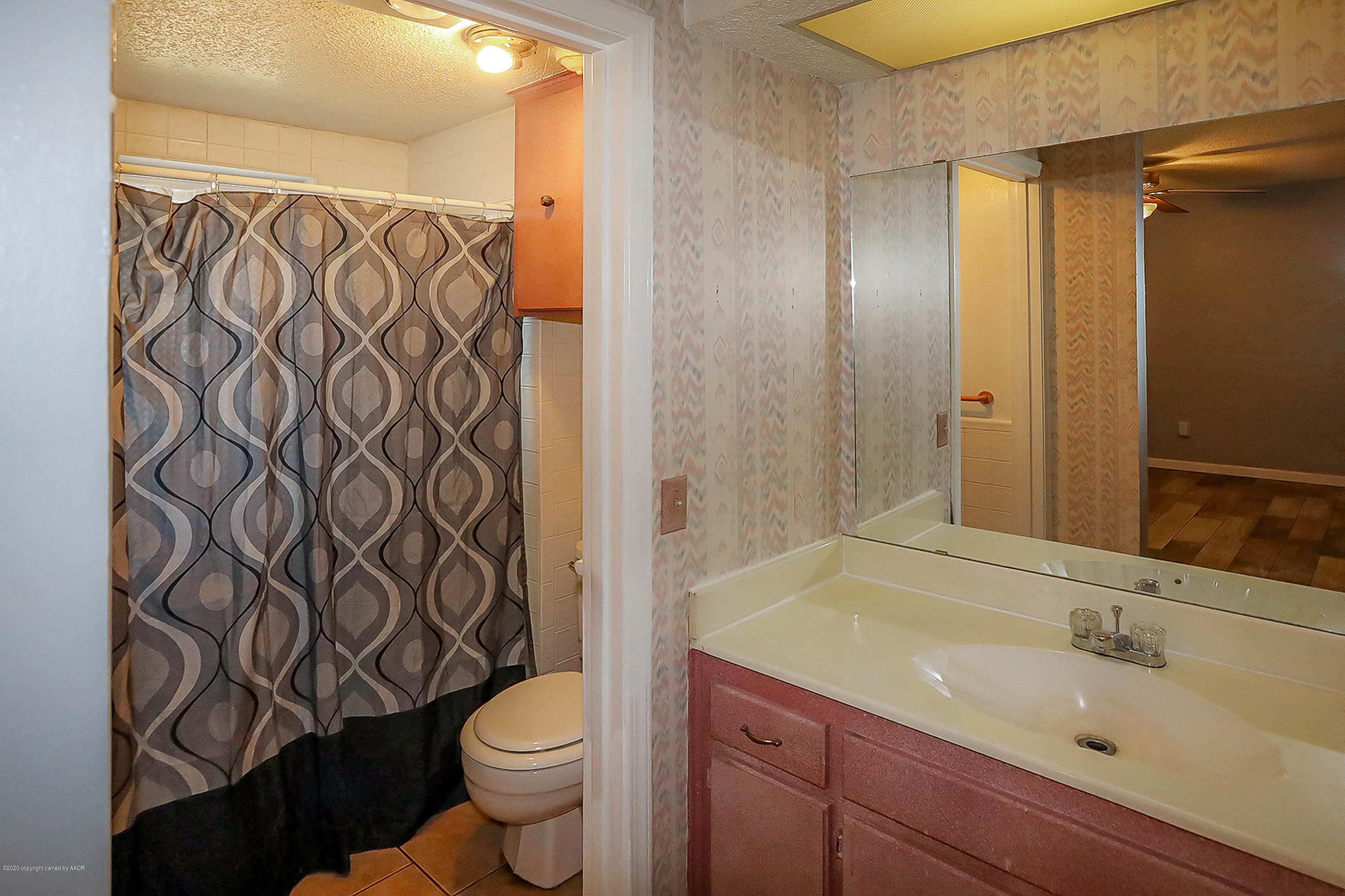 2802 Shield Court Amarillo, TX 79110 - Photo 17 of 32 a bathroom with a granite countertop sink a toilet and a mirror