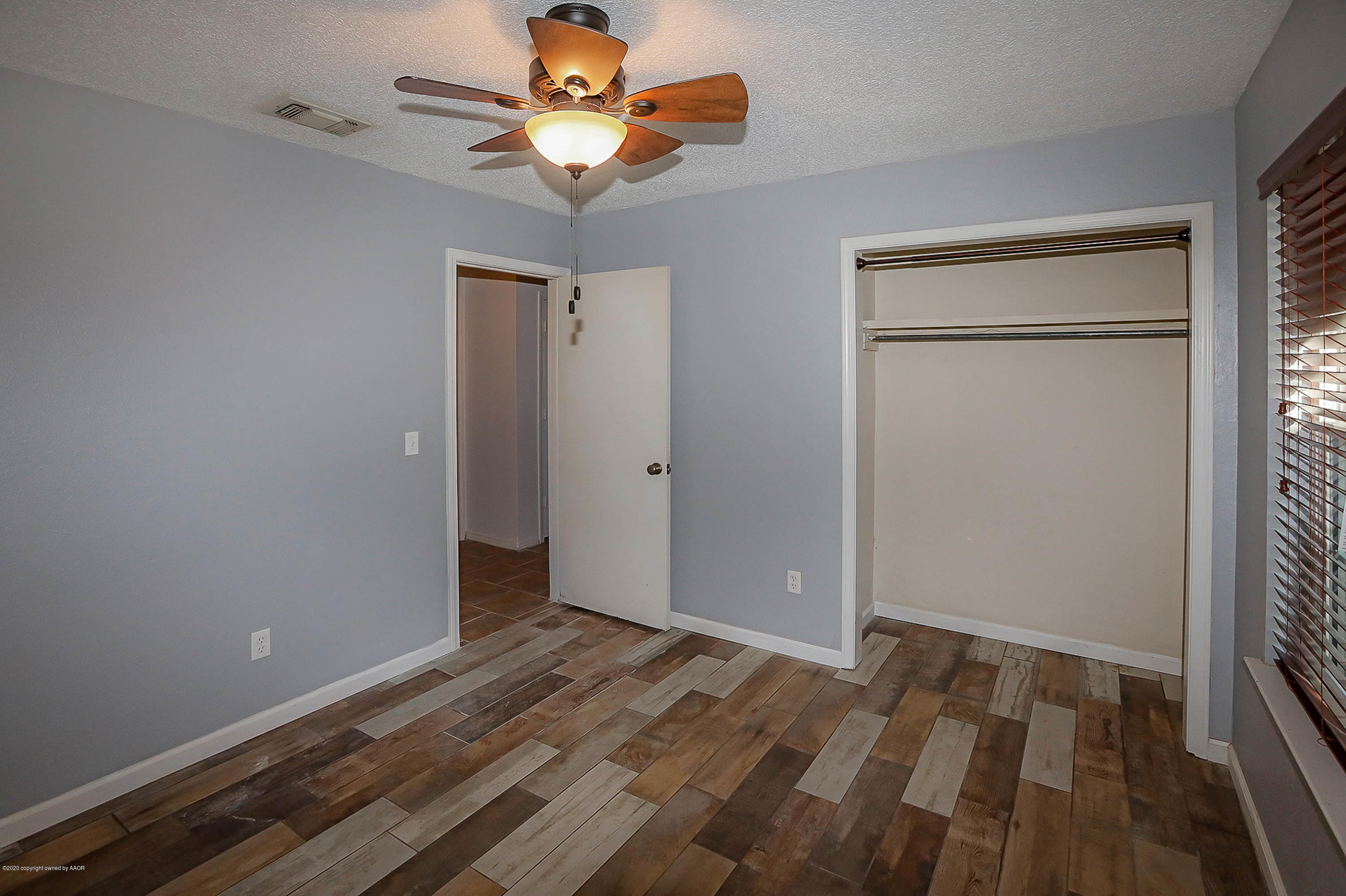 2802 Shield Court Amarillo, TX 79110 - Photo 19 of 32 wooden floor in an empty room with a window
