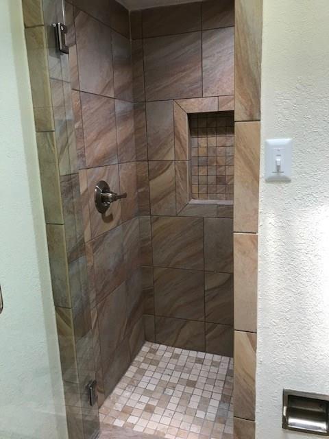 18240 Midway Road, Unit 303 Dallas, TX 75287 - Photo 20 of 22 Bathroom with a shower stall and a textured wall