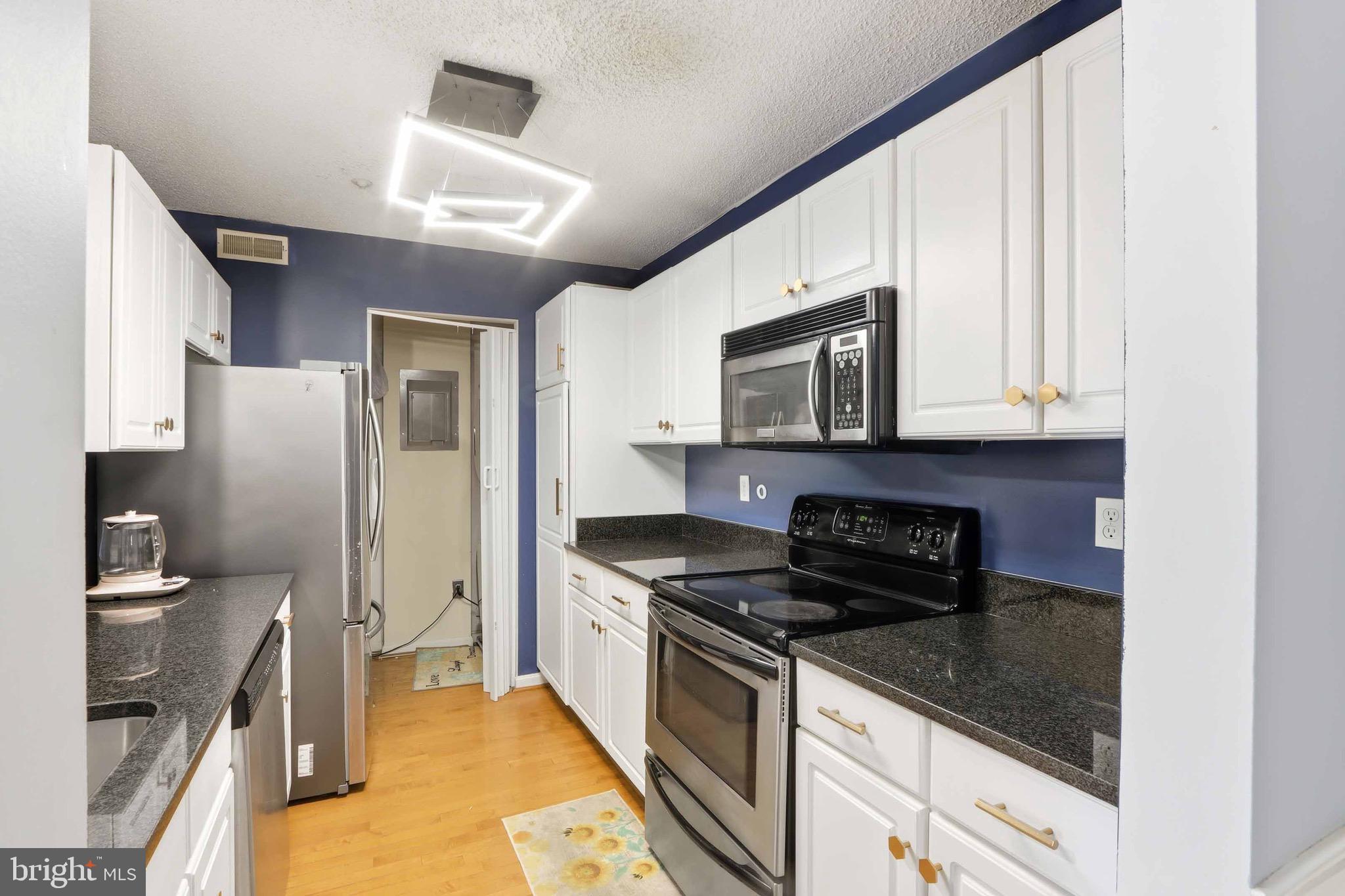 12909 Churchill Ridge Circle, Unit 12 Germantown, MD 20874 - Photo 13 of 44 a kitchen with stainless steel appliances granite countertop a stove a sink and a microwave