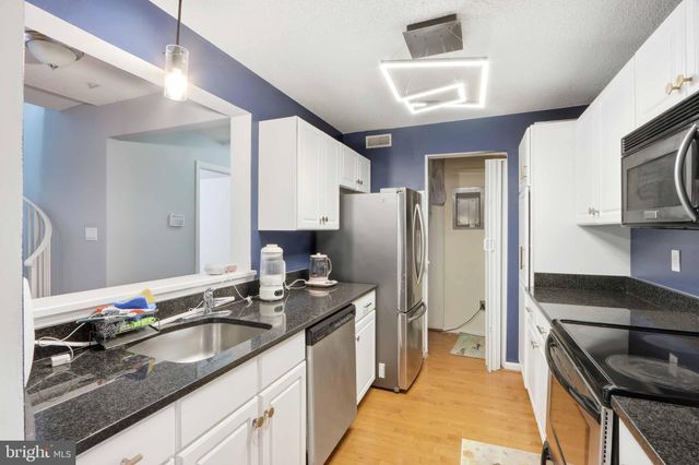 a kitchen with granite countertop a sink and cabinets