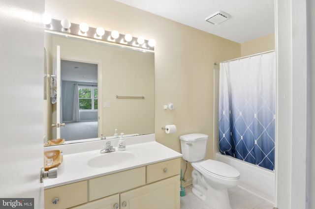 a bathroom with a shower curtain and a toilet next to a window