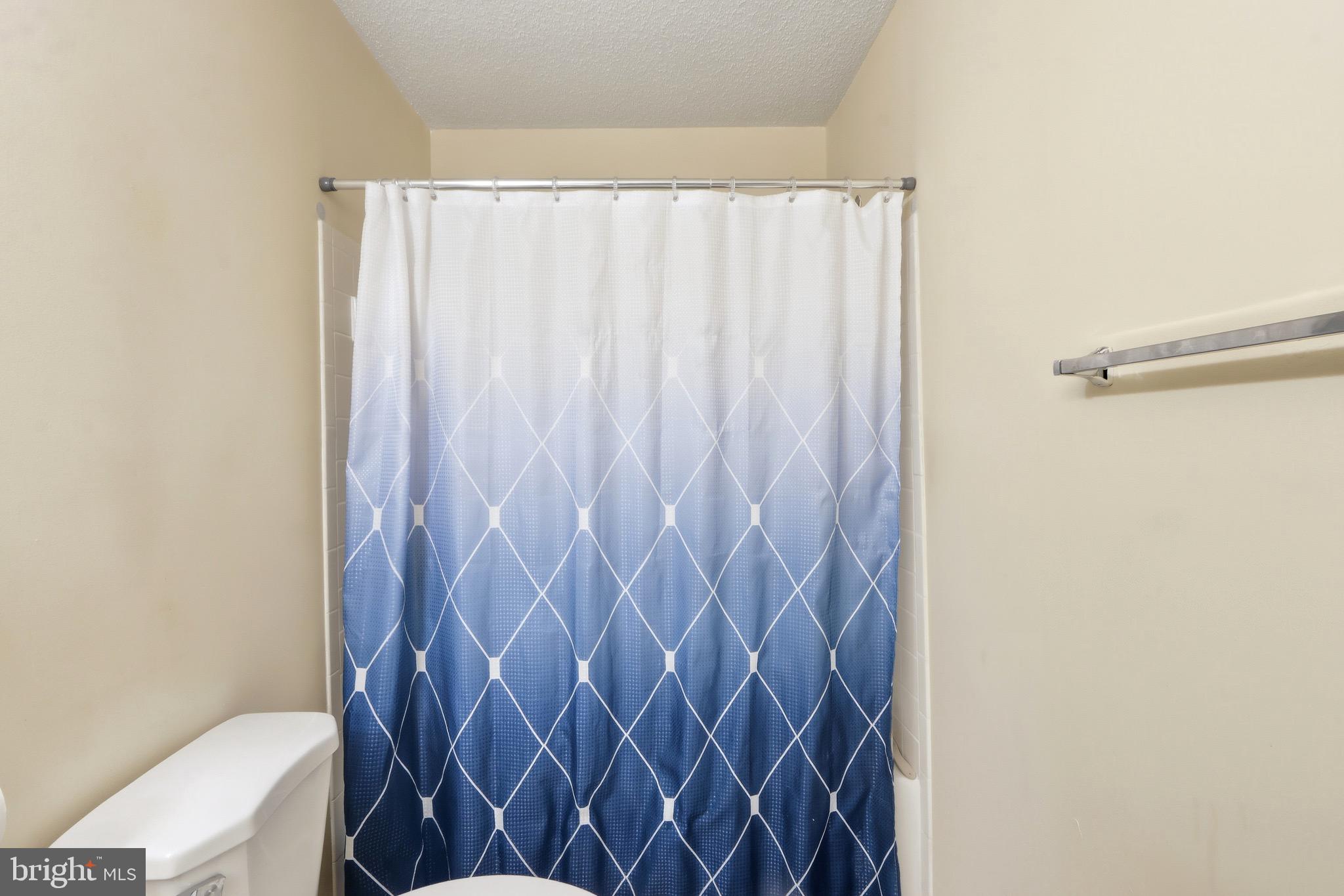 12909 Churchill Ridge Circle, Unit 12 Germantown, MD 20874 - Photo 23 of 44 a bathroom with a shower curtain and a toilet next to a window