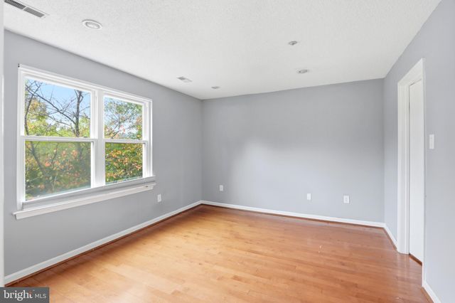 a view of an empty room with window and closet area
