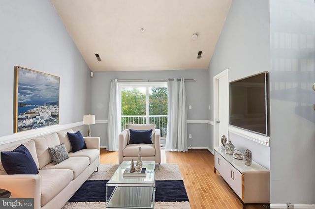 a living room with furniture a flat screen tv and a large window