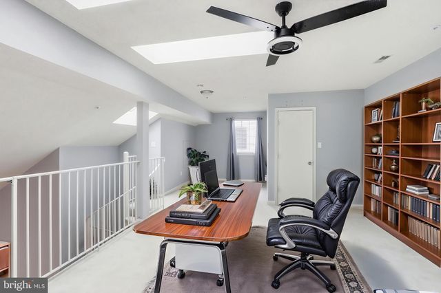 a workspace with furniture bookshelf and a window