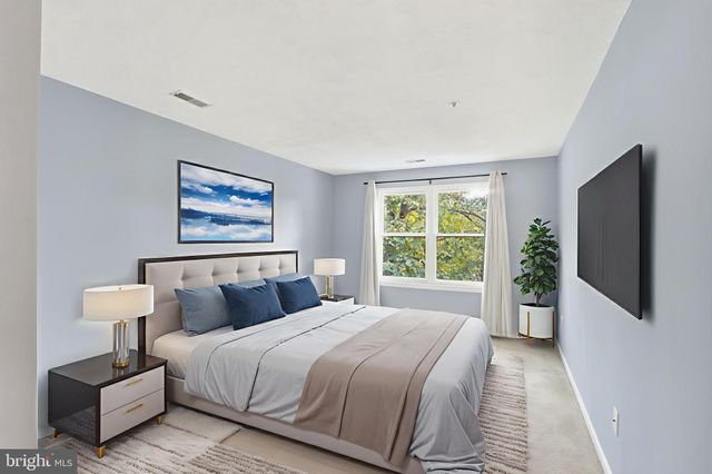 a bedroom with bed and a potted plant next to a window